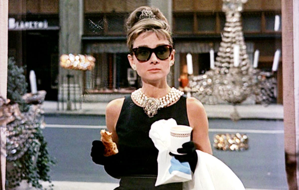 Audrey Hepburn in front of Tiffany's in a black dress and sunglasses.